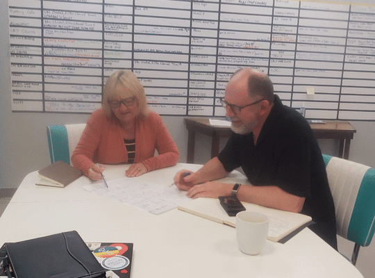 Image of Paula Greeley and Rob McClellan of Clean Start planning at a table 