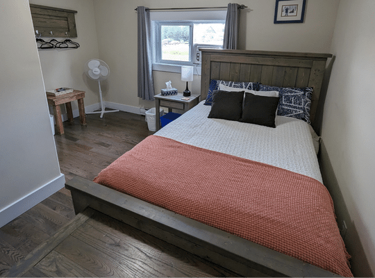 Comfortable Bed with Peach Bedspread at Trailway Hub