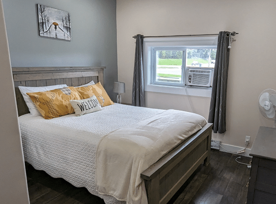 Comfortable Bed with white Bedspread at Trailway Hub