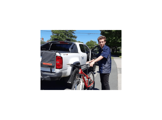 young man with a bicycle by the FlatOut truck