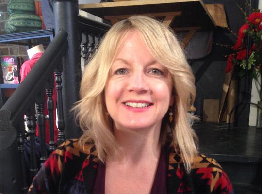 Kim Winsor, store owner, in front of a black staircase in the store