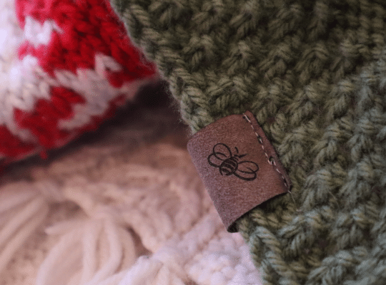 The Bee Sisters logo tag on a green quilt