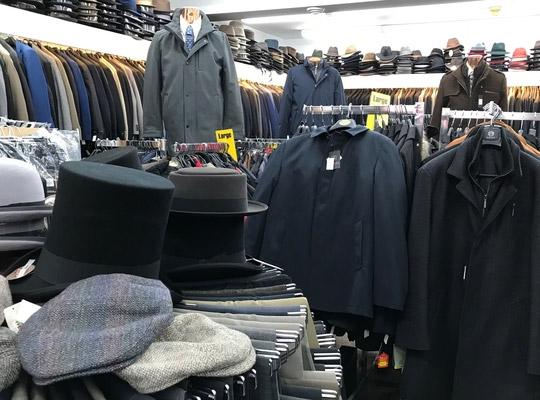 racks full of coats with hats stacked on them