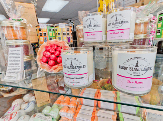 bright, clear display of products sold at the Heritage Shops - foggy island candles, row houses, and soap