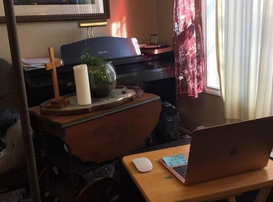 a cross, a candle, a plant and a laptop - everything Reverend Miriam Bowlby needs to bring Cochrane Street United Church's Sunday service live