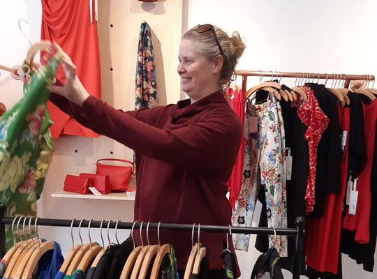smiling Johnny Ruth customer admiring a dress