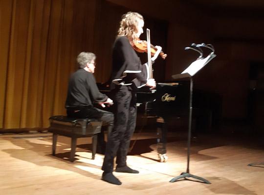 man playing piano and woman playing violin