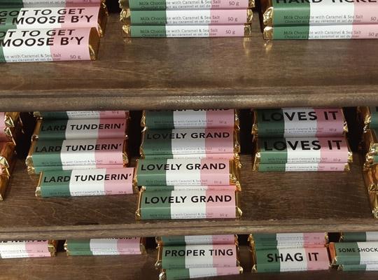 bars of chocolate wrapped in pink white and green wrappers with various sayings, like 'Lovely Grand'