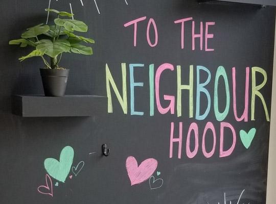 chalk board sign that reads to the Neighbourhood