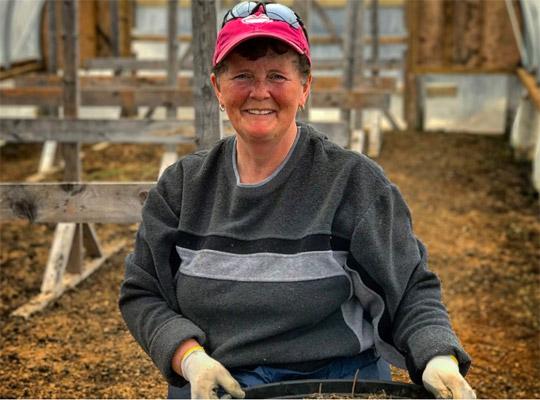 a woman smiling in a barn